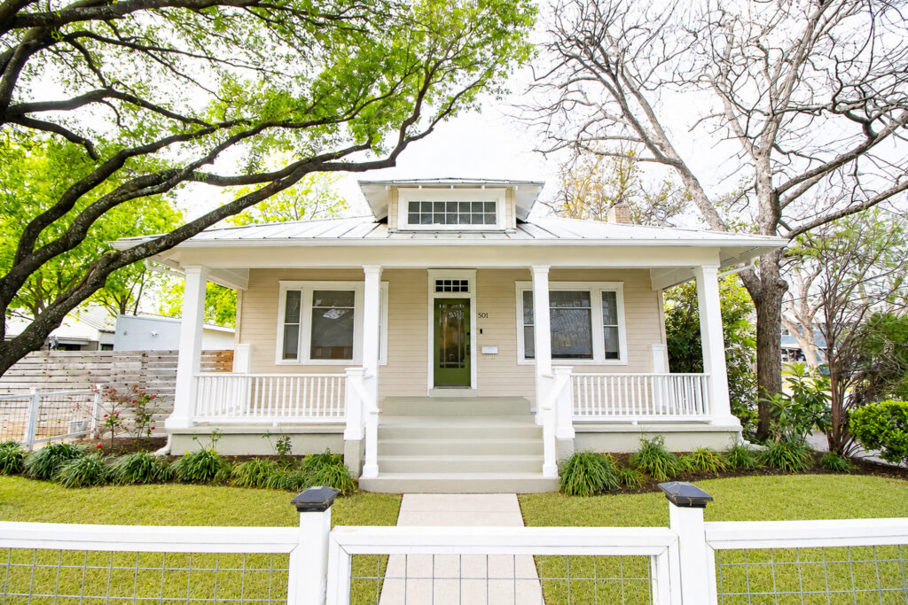 Front exterior of restored historic Hyde Park home at 501 Park Blvd in Austin, Texas with covered front porch and mature trees